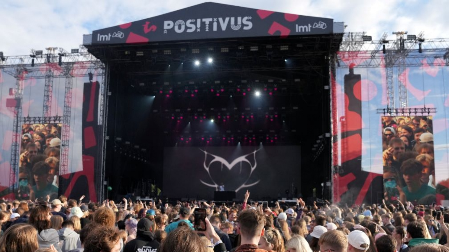 Festivāla “Positivus” koncerta skatuve ar ekrāniem un apmeklētāji 